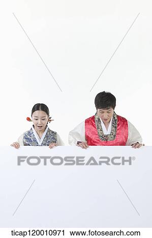 Stock Image - a couple in Hnabok holding an empty whiteboard. Fotosearch