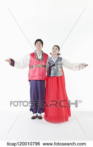 Stock Photograph - a couple spreading arms wearing Hanbok . Fotosearch