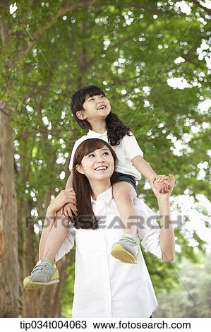 a daughter on mother's shoulders in forest View Large Photo Image Stock Image - a daughter on mother's shoulders in forest . Fotosearch