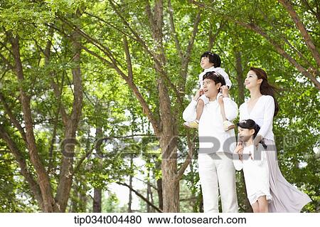 Stock Image - a family in a forest looking up. Fotosearch