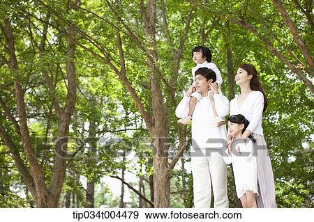 Stock Photo - a family in a forest looking up. Fotosearch