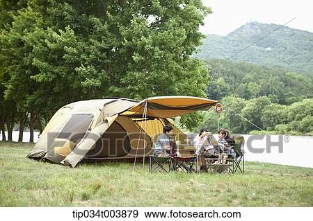 a family in camping place having a meal next to a lake View Large Photo Image Stock Photo - a family in camping place having a meal next to a lake . Fotosearch