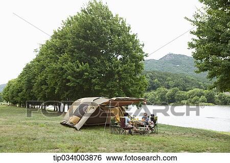 Stock Photograph - a family in camping place having a meal. Fotosearch