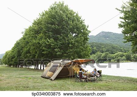 Stock Photography - a family in camping place having a meal. Fotosearch