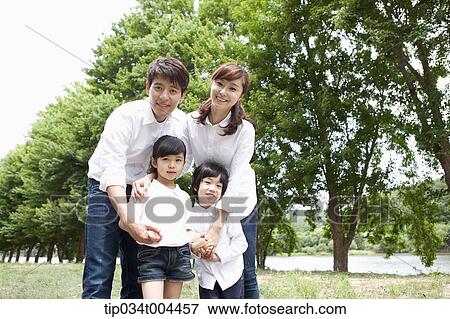 a family posing with trees behind View Large Photo Image Stock Photo - a family posing with trees behind . Fotosearch