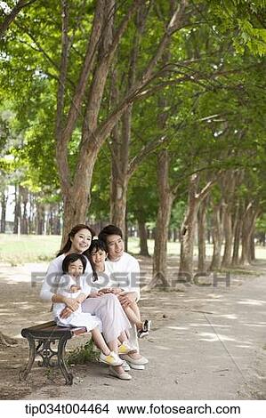 Picture - a family sitting on a bench . Fotosearch