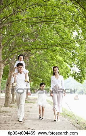a family with kids walking along a trail with trees View Large Photo Image Stock Photo - a family with kids walking along a trail with trees. Fotosearch