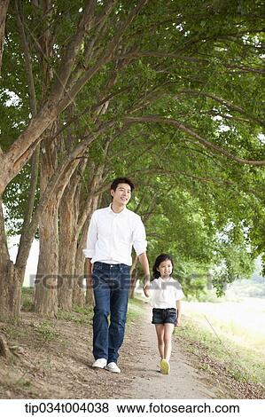 a father and a daughter taking a walk along trees View Large Photo Image Stock Photo - a father and a daughter taking a walk along trees . Fotosearch