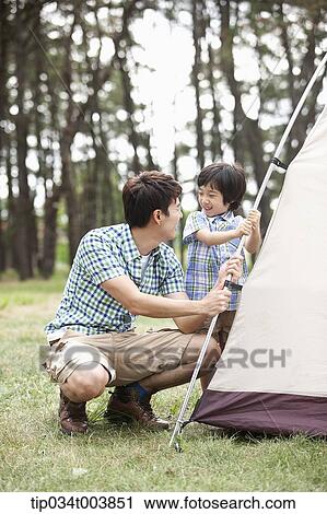 a father and son building a tent in camping place View Large Photo Image Stock Image - a father and son building a tent in camping place. Fotosearch