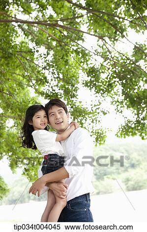 a father holding a daughter under a tree View Large Photo Image Stock Photography - a father holding a daughter under a tree. Fotosearch
