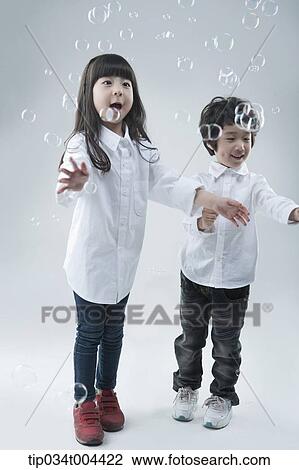 a female and a male kids playing with bubbles View Large Photo Image Stock Image - a female and a male kids playing with bubbles . Fotosearch