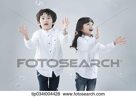 a female and a male kids playing with bubbles View Large Photo Image Stock Photo - a female and a male kids playing with bubbles . Fotosearch