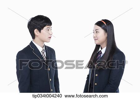 Stock Image - a female and a male student with school uniform facing each other. Fotosearch