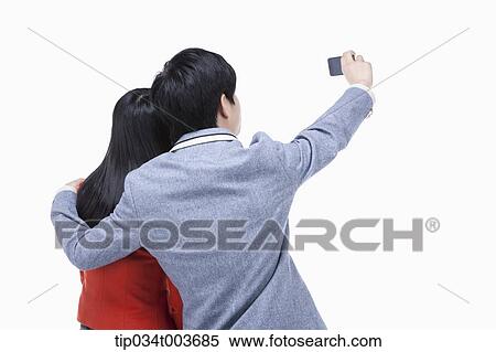 a female and male student's back of them taking a photo with a mobile phone View Large Photo Image Stock Photography - a female and male student's back of them taking a photo with a mobile phone . Fotosearch
