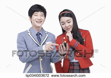 Stock Image - a female and male students using a smartphone . Fotosearch