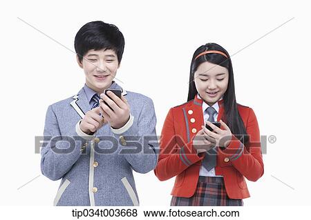 Stock Photo - a female and male students using their mobile phones . Fotosearch