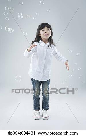 a female kid playing with bubbles View Large Photo Image Stock Image - a female kid playing with bubbles. Fotosearch