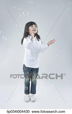a female kid trying to catch bubbles View Large Photo Image Stock Image - a female kid trying to catch bubbles. Fotosearch