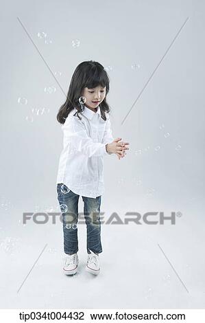 a female kid trying to catch bubbles View Large Photo Image Stock Image - a female kid trying to catch bubbles. Fotosearch