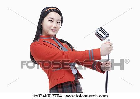 Picture - a female student grabbing a microphone stand with two hands . Fotosearch