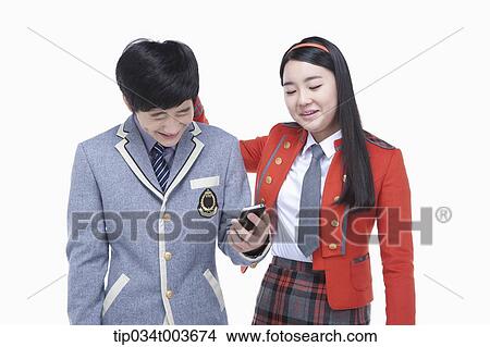 a female student hitting male student's neck while reading his smartphone screen View Large Photo Image Picture - a female student hitting male student's neck while reading his smartphone screen . Fotosearch