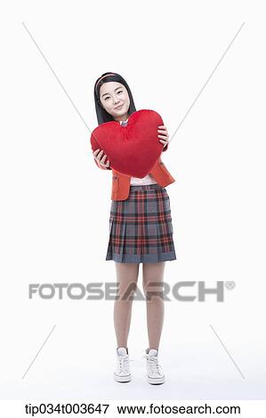 a female student holding a red heart cushion View Large Photo Image Stock Photo - a female student holding a red heart cushion . Fotosearch
