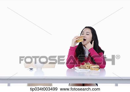 a female student in red sweater having a burger View Large Photo Image Stock Photo - a female student in red sweater having a burger. Fotosearch