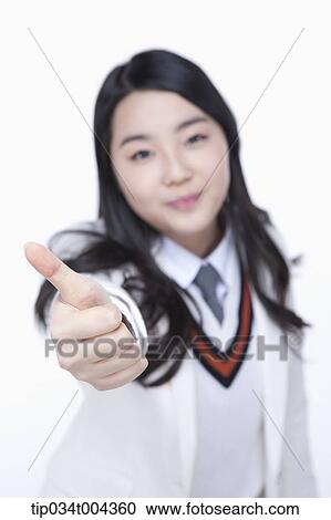 a female student in school uniform wearing a white jacket showing thumbs up towards camera View Large Photo Image Stock Image - a female student in school uniform wearing a white jacket showing thumbs up towards camera. Fotosearch