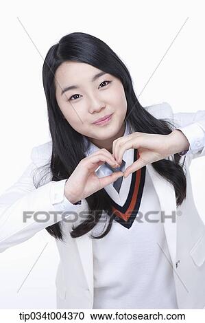 a female student in school uniform making heart symbol with her hands View Large Photo Image Stock Image - a female student in school uniform making heart symbol with her hands . Fotosearch