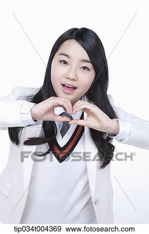 a female student in school uniform making heart symbol with her hands View Large Photo Image Stock Photo - a female student in school uniform making heart symbol with her hands . Fotosearch