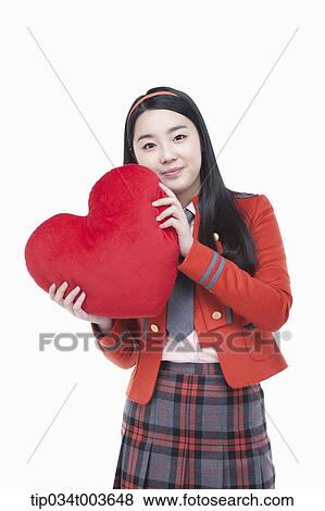 a female student posing with a red heart cushion View Large Photo Image Stock Photo - a female student posing with a red heart cushion. Fotosearch