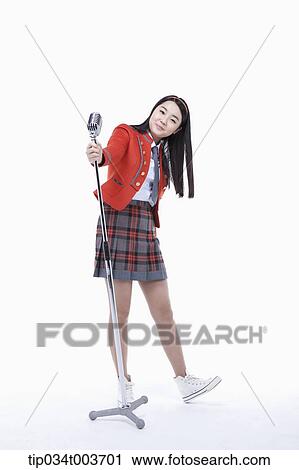 Stock Image - a female student pulling a microphone stand . Fotosearch