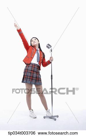 a female student spreading her arm while grabbing microphone stand with the other hand View Large Photo Image Stock Photograph - a female student spreading her arm while grabbing microphone stand with the other hand . Fotosearch