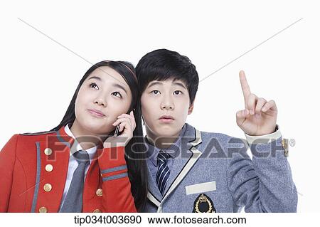 a female student talking on a mobile phone while male student tries to overhear View Large Photo Image Stock Image - a female student talking on a mobile phone while male student tries to overhear. Fotosearch