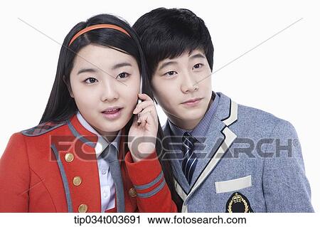 a female student talking on a mobile phone while male student tries to overhear View Large Photo Image Stock Image - a female student talking on a mobile phone while male student tries to overhear. Fotosearch