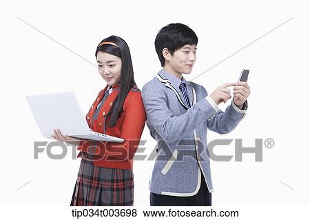 Stock Photo - a female student using laptop and male student using a mobile phone. Fotosearch