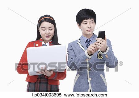 Stock Photography - a female student using laptop and male student using a mobile phone. Fotosearch