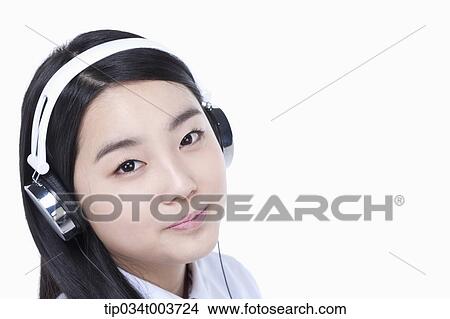 Picture - a female student wearing a headphone. Fotosearch