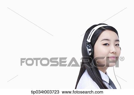 Stock Image - a female student wearing a headphone. Fotosearch