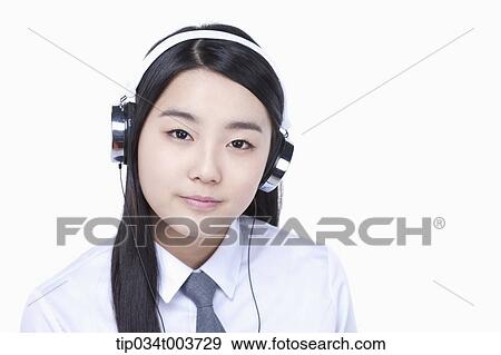 Stock Photo - a female student wearing a headphone. Fotosearch