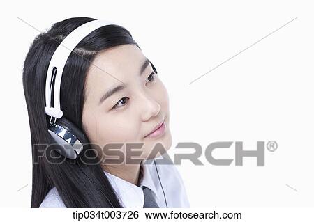 Stock Photograph - a female student wearing a headphone. Fotosearch