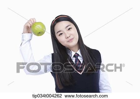a female student wearing school uniform holding a green apple View Large Photo Image Stock Image - a female student wearing school uniform holding a green apple . Fotosearch