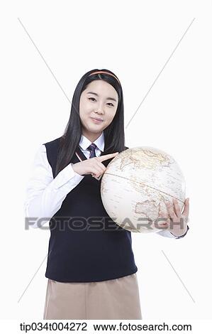 a female student wearing school uniform pointing at a globe View Large Photo Image Stock Image - a female student wearing school uniform pointing at a globe . Fotosearch