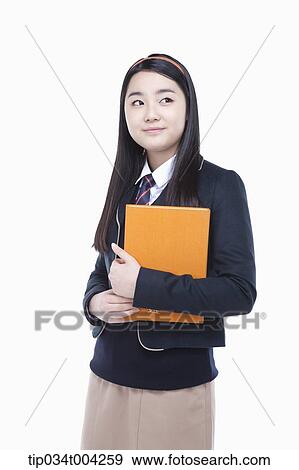 a female student wearing school uniform holding a book in her arms View Large Photo Image Stock Photo - a female student wearing school uniform holding a book in her arms . Fotosearch