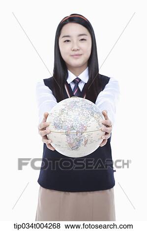 Stock Photo - a female student wearing school uniform holding a globe with two hands. Fotosearch