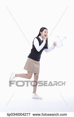 a female student wearing school uniform running with a garden kettle View Large Photo Image Stock Photo - a female student wearing school uniform running with a garden kettle. Fotosearch