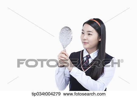 a female student wearing school uniform looking at herself through a mirror View Large Photo Image Stock Photo - a female student wearing school uniform looking at herself through a mirror. Fotosearch