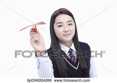 Stock Photograph - a female student wearing school uniform ready to throw a paper airplane . Fotosearch