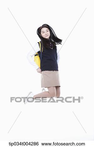 Stock Photograph - a female student wearing school uniform and a school bag jumping . Fotosearch