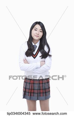 Stock Photography - a female student wearing school uniform standing with arms crossed. Fotosearch